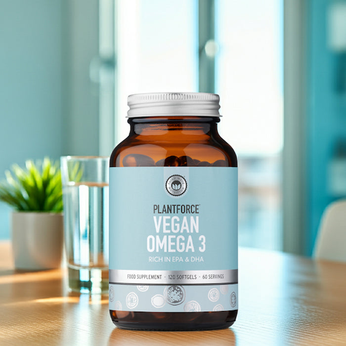 Bottle of Plantforce Vegan Omega 3 supplement on a table with a blurred indoor background
